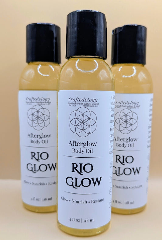 Three bottles of Rio Glow Afterglow Body Oil on a beige background